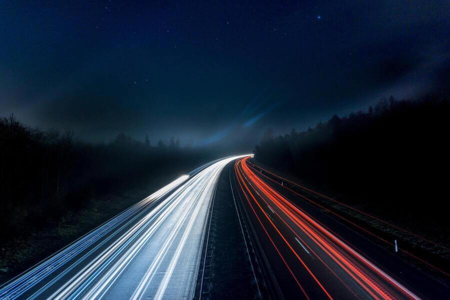 Car tail light trails on a highway at night