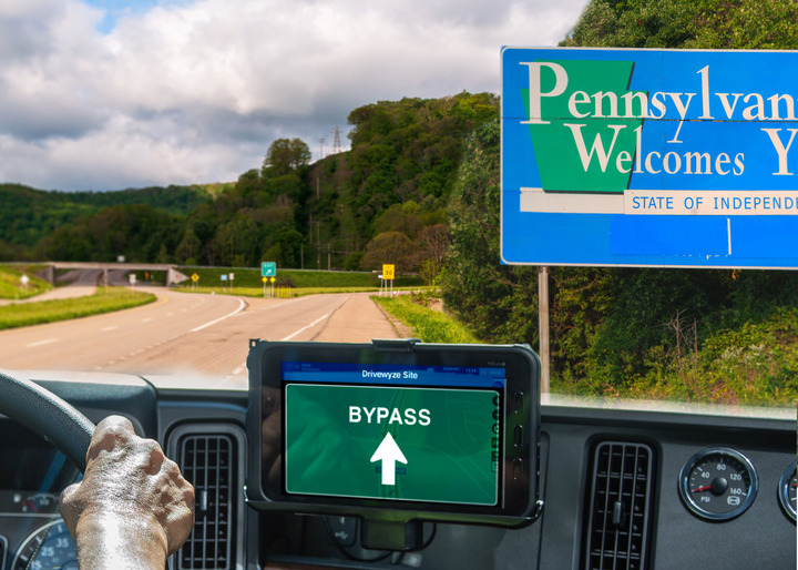 Truck driver views the road ahead while using bypass management technology when driving into Pennsylvania