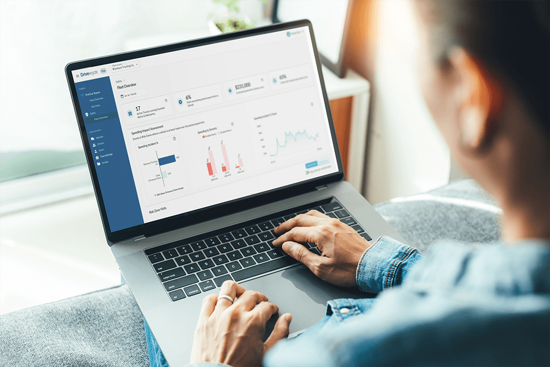 A person is using a laptop with a partner dashboard showcasing analytics, including a line graph, bar chart, and statistical data. The screen displays information about preclear programs. They sit on the sofa, interacting confidently with the keyboard and trackpad.