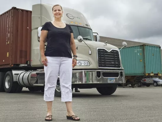Woman Standing in Front of Bar Ole Trucking Truck in Trucking Yard